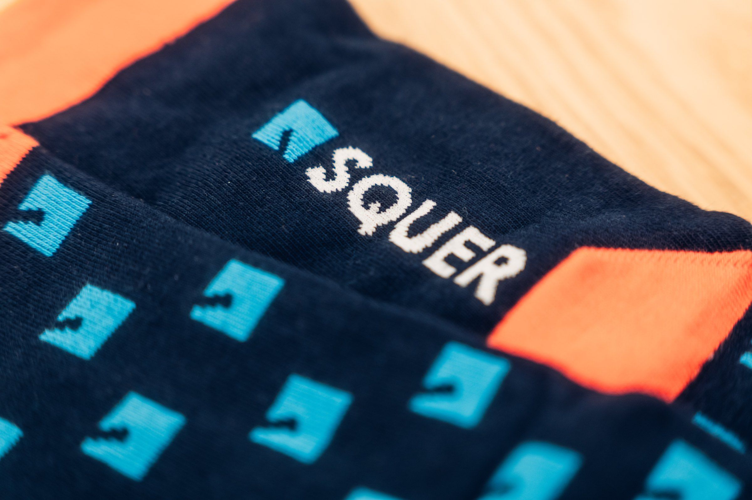 Gestrickte Socken für SQUER, Logo eingestrickt, Detail Bund in Navy und Orange